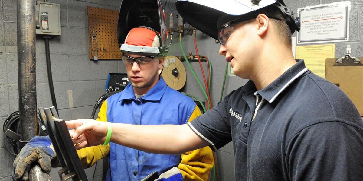 AACC welding student receives instruction.